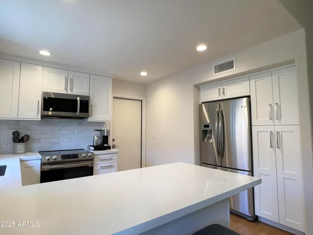 a kitchen with stainless steel appliances a refrigerator stove microwave and sink