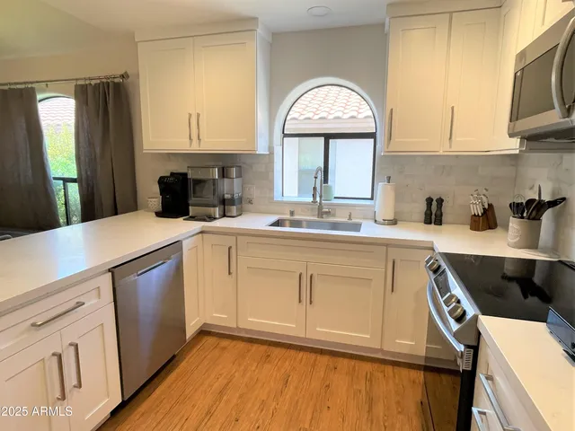 a kitchen with a sink a stove and cabinets