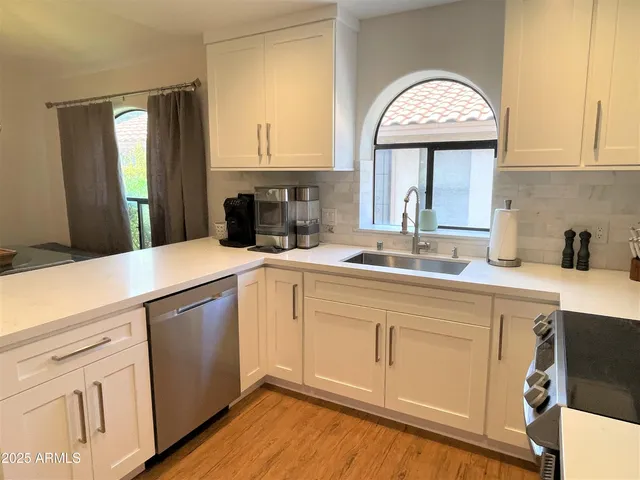 a kitchen with a sink cabinets and a wooden floor