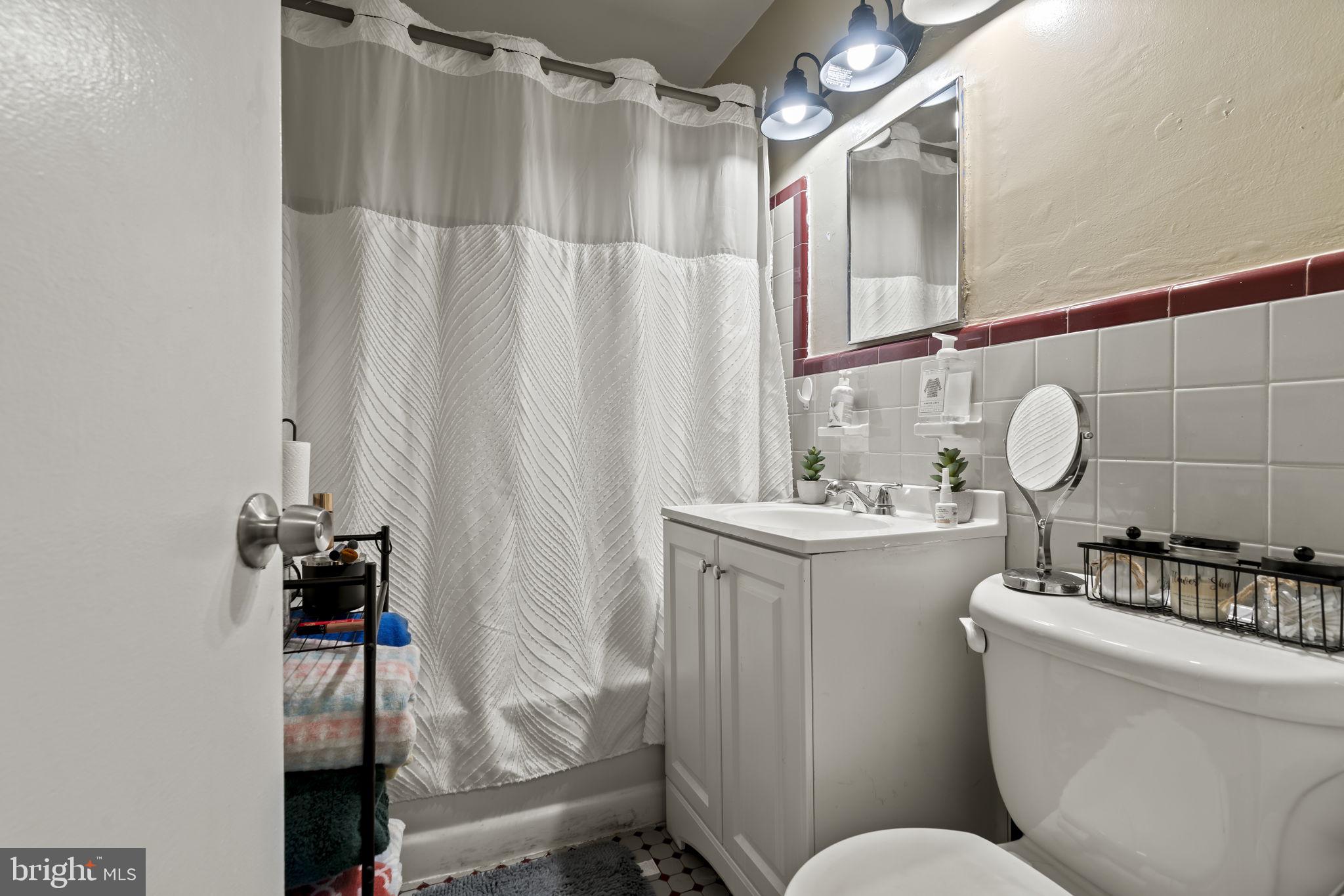 6014 Oakland Street Philadelphia, PA 19149 - Photo 4 of 13 a bathroom with a sink vanity mirror and toilet