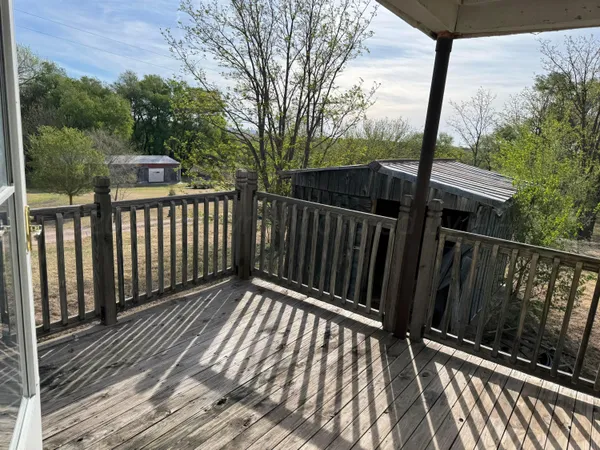 a view of balcony with wooden floor and fence