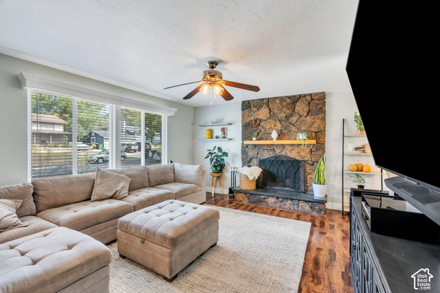 892 Bear Canyon Road Sandy, UT 84094 - Photo 5 of 36 Stone-surround fireplace with a wood mantle, wood-finish flooring, and a ceiling fan