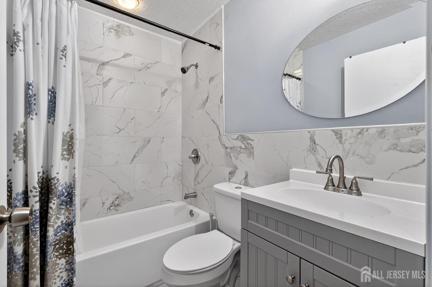 99 Kelly Drive Edison, NJ 08820 - Photo 15 of 29 a bathroom with a sink a toilet a mirror a bathtub and shower