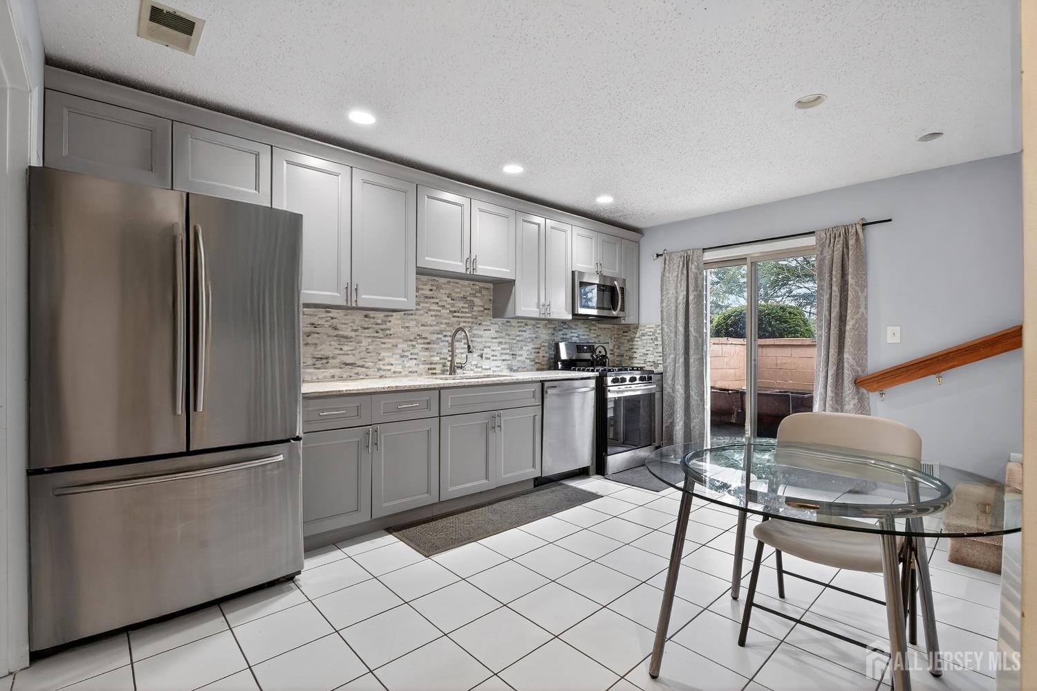 99 Kelly Drive Edison, NJ 08820 - Photo 6 of 29 a kitchen with a refrigerator a table and chairs