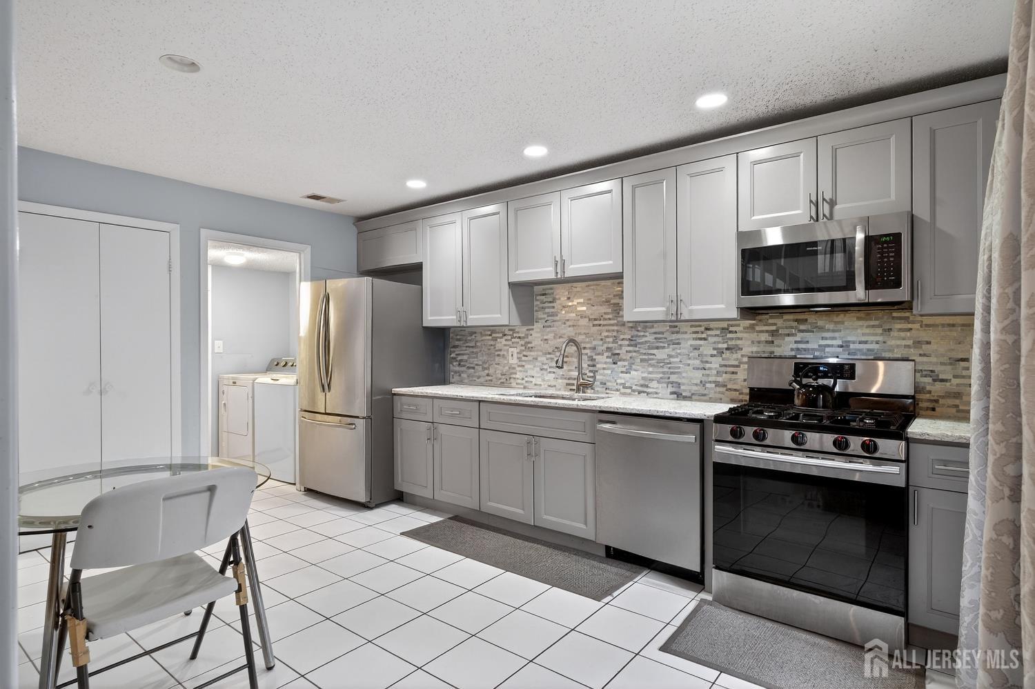 99 Kelly Drive Edison, NJ 08820 - Photo 7 of 29 a kitchen with a stove a sink and a refrigerator