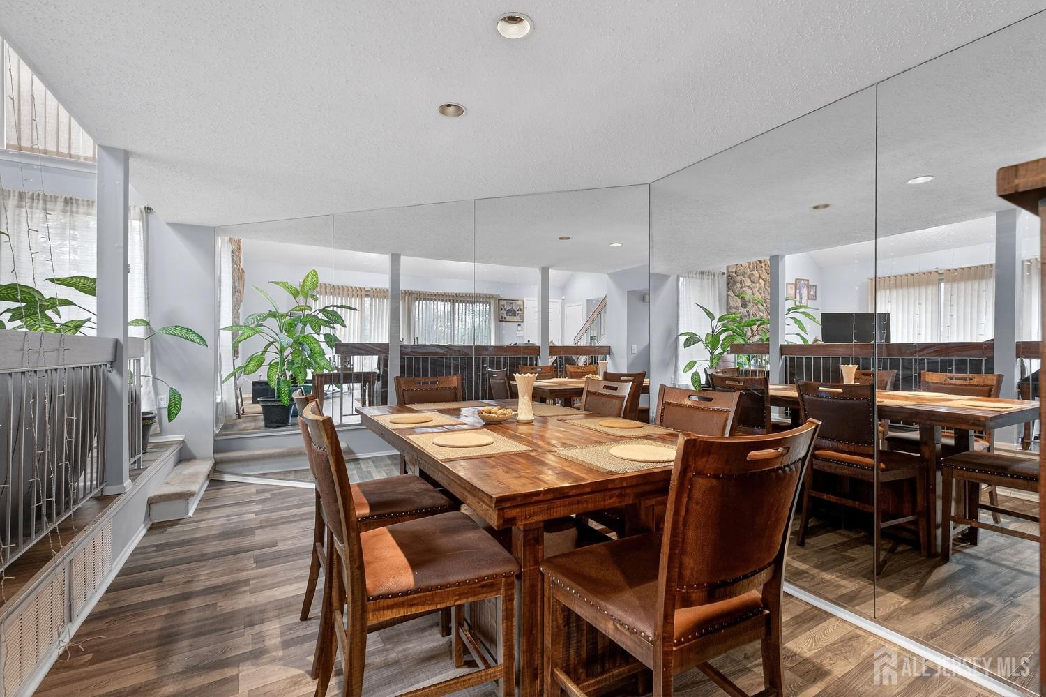 99 Kelly Drive Edison, NJ 08820 - Photo 9 of 29 a view of a dining room and livingroom with furniture wooden floor a rug a potted plant and a painting