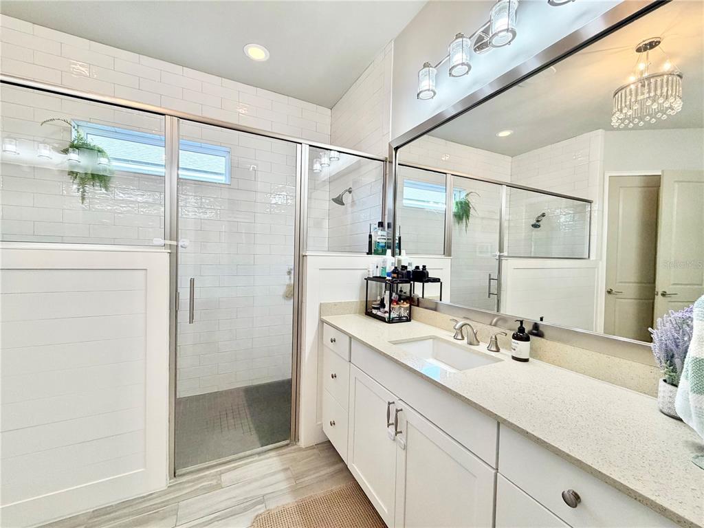 11931 Southwest 32nd Lane Gainesville, FL 32608 - Photo 25 of 78 a bathroom with a double vanity sink a mirror and shower