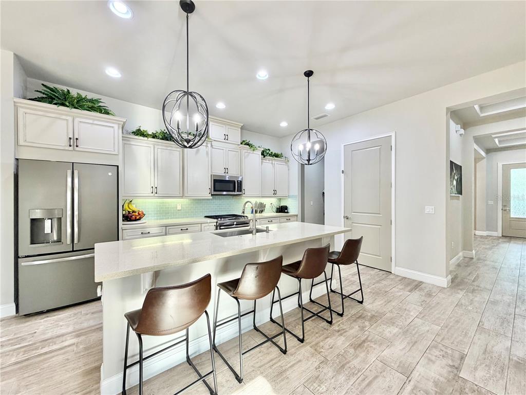 11931 Southwest 32nd Lane Gainesville, FL 32608 - Photo 4 of 78 a kitchen with stainless steel appliances a table chairs and chandelier