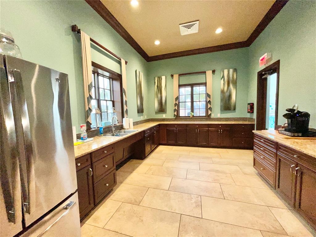 11931 Southwest 32nd Lane Gainesville, FL 32608 - Photo 67 of 78 a large kitchen with kitchen island granite countertop a large counter top stainless steel appliances a sink and cabinets