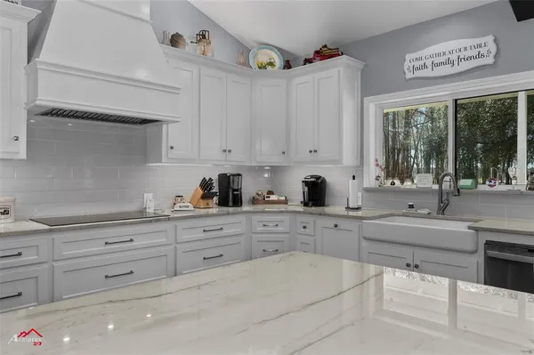 a kitchen with stainless steel appliances kitchen island granite countertop a table chairs in it and wooden floors