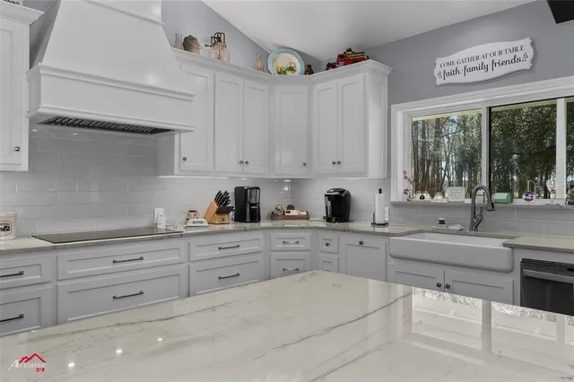 a kitchen with stainless steel appliances kitchen island granite countertop a table chairs in it and wooden floors