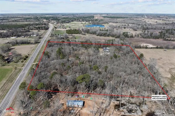 a view of a dry yard with wooden fence