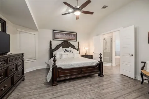 a bedroom with a bed and a flat tv screen on the dresser