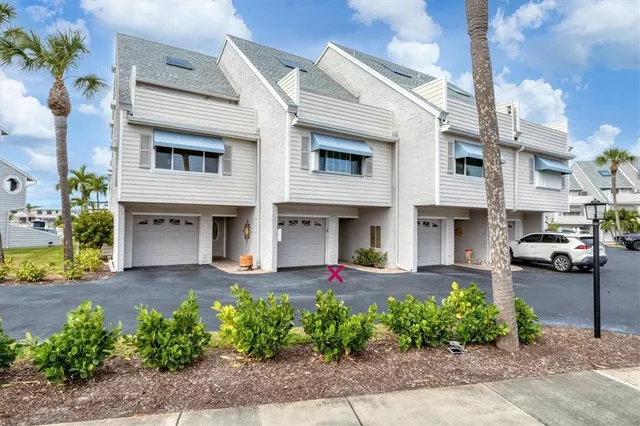 a view of a white building among the side of a street