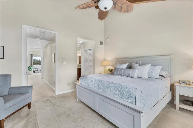 a bedroom with a large bed and a potted plant