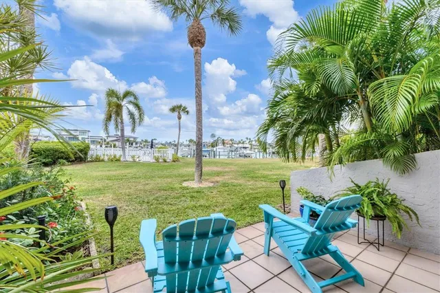 a view of a swimming pool and lounge chairs in back yard of a house