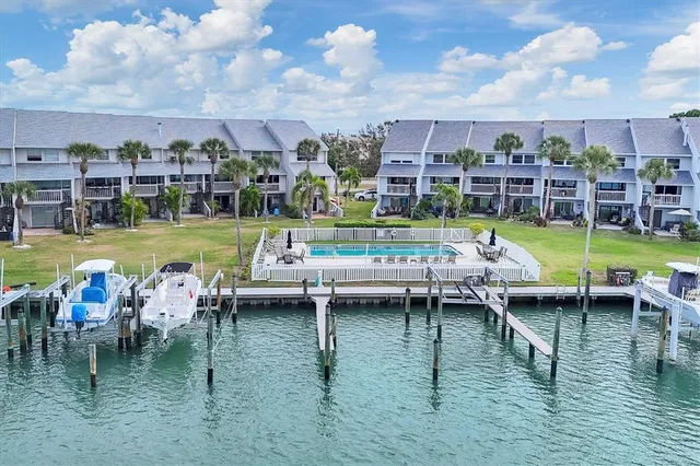 a view of a swimming pool and lounge chairs in back yard of the house