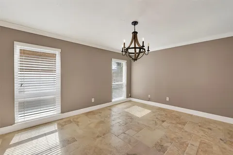 a view of a livingroom with a chandelier fan and windows