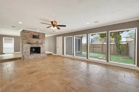 a view of an empty room with a fireplace and a large window