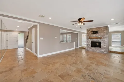 a view of a livingroom with a fireplace a sink and a chandelier