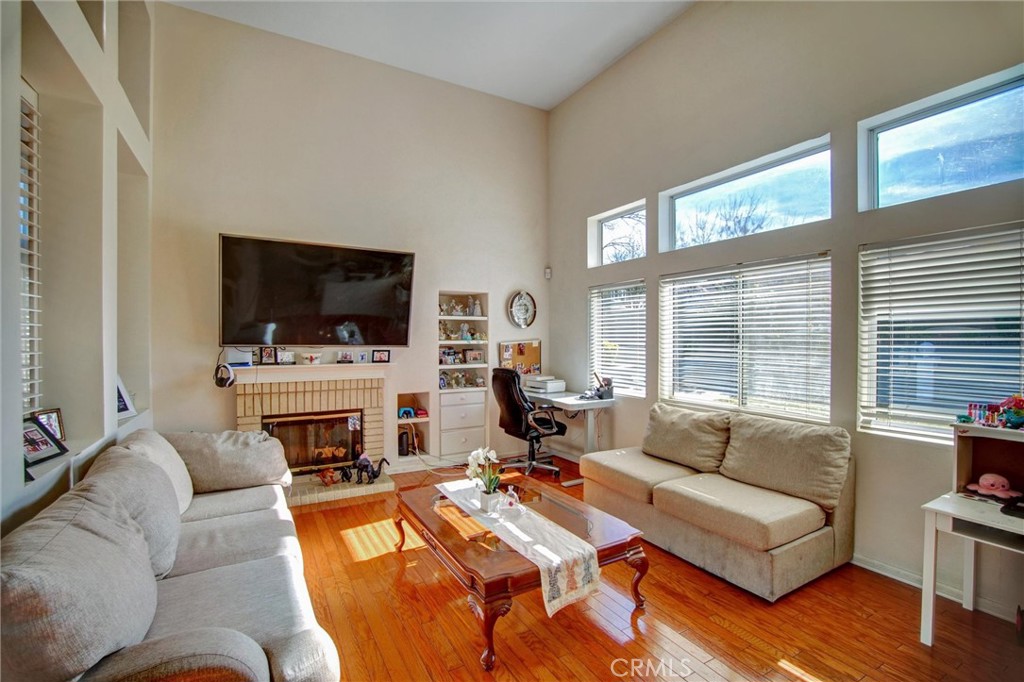1072 Silvercreek Road Corona, CA 92882 - Photo 13 of 31 a living room with furniture a fireplace and a flat screen tv