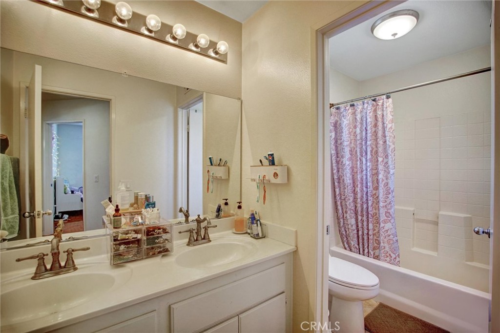 1072 Silvercreek Road Corona, CA 92882 - Photo 29 of 31 a bathroom with a double vanity sink toilet and shower
