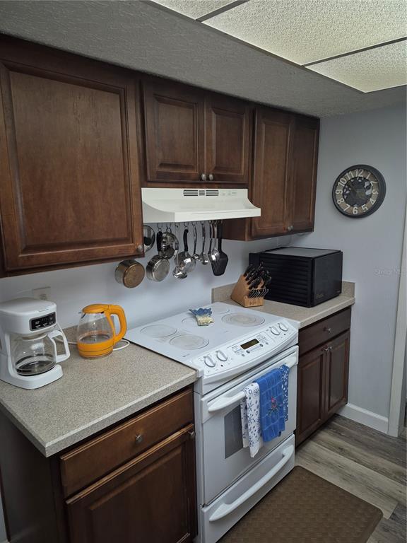 7614 Radcliffe Circle, Unit 104B Port Richey, FL 34668 - Photo 5 of 17 a kitchen with a sink a stove and cabinets