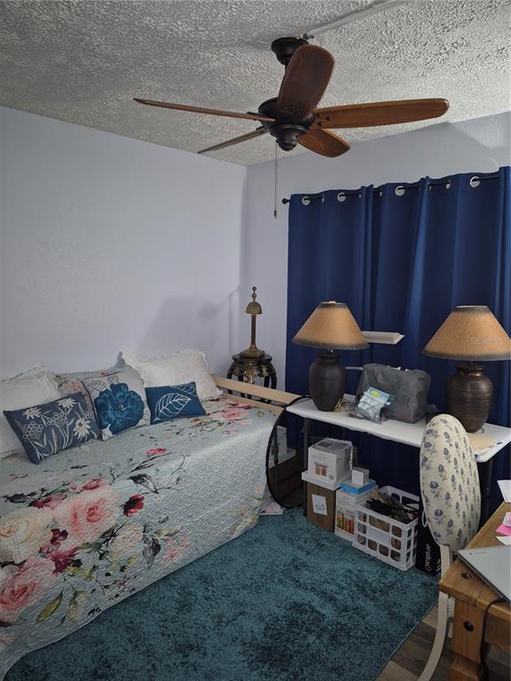 7614 Radcliffe Circle, Unit 104B Port Richey, FL 34668 - Photo 6 of 17 a bed room with furniture and a lamp