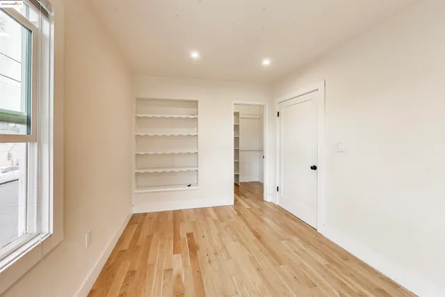 a view of a room with wooden floor and a window