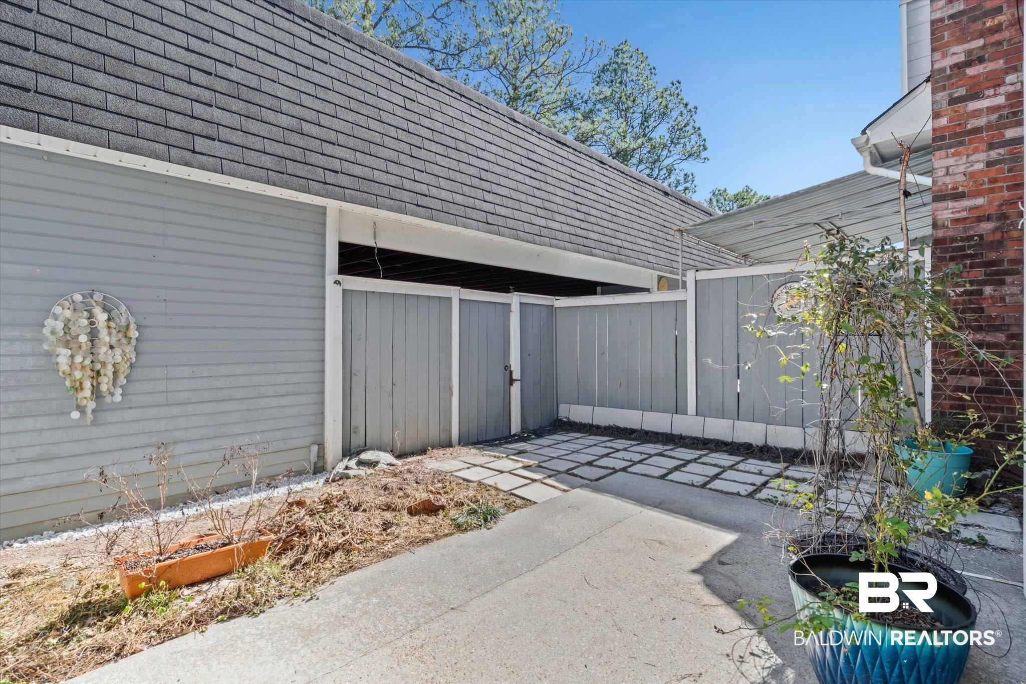 5900 Grelot Road, Unit 504 Mobile, AL 36609 - Photo 17 of 24 View of side of home with a shingled roof and a patio