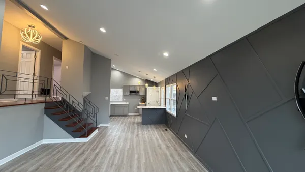 a open kitchen with a sink and wooden floor