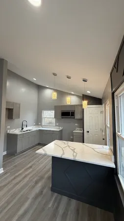 a large kitchen with kitchen island a sink stainless steel appliances and cabinets