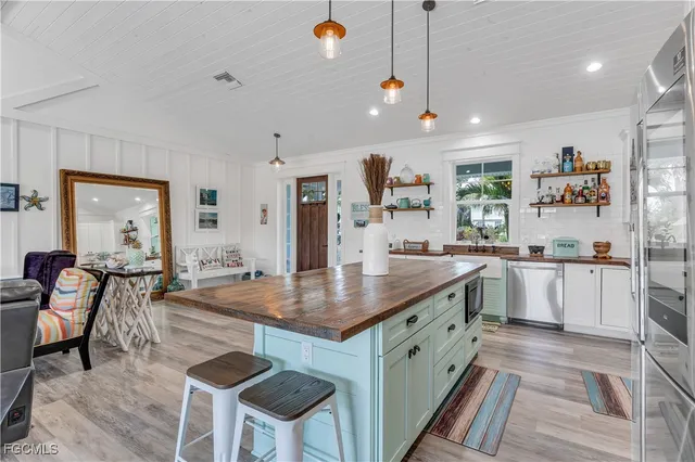 a kitchen with stainless steel appliances granite countertop a stove a sink a microwave a dining table and chairs