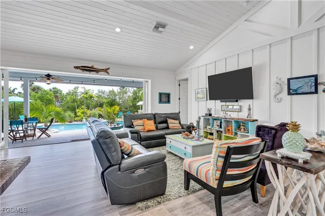 a living room with patio furniture and a flat screen tv