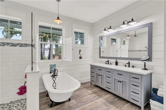 a bathroom with a double vanity sink mirror and bathtub
