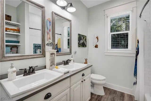 a bathroom with a granite countertop sink toilet and mirror