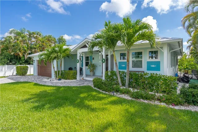 a view of a house with a yard and potted plants
