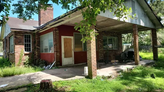 a view of a barn with a table and chairs under an umbrella