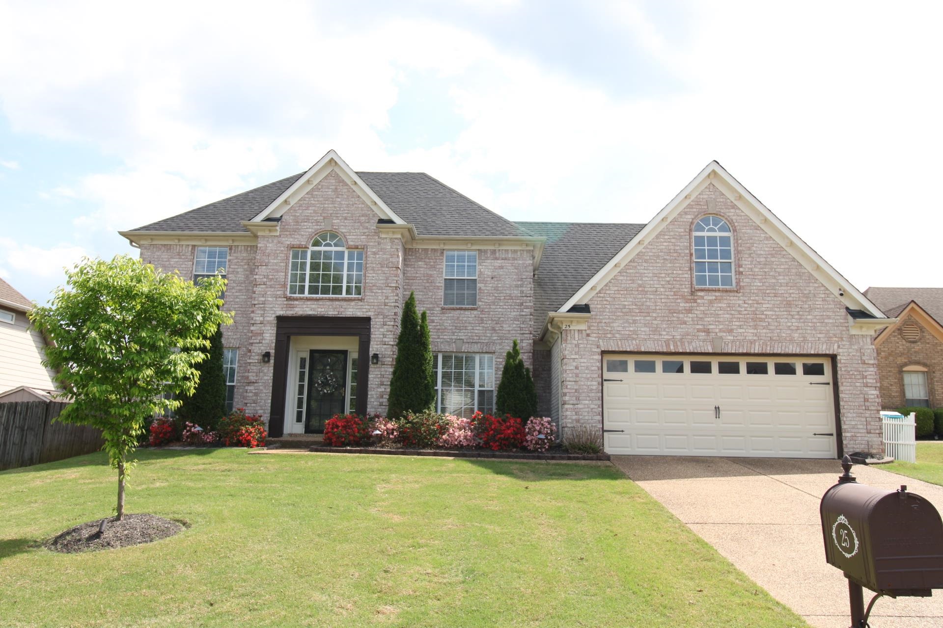 Traditional-style house with brick siding, concrete driveway, a garage, and roof with shingles