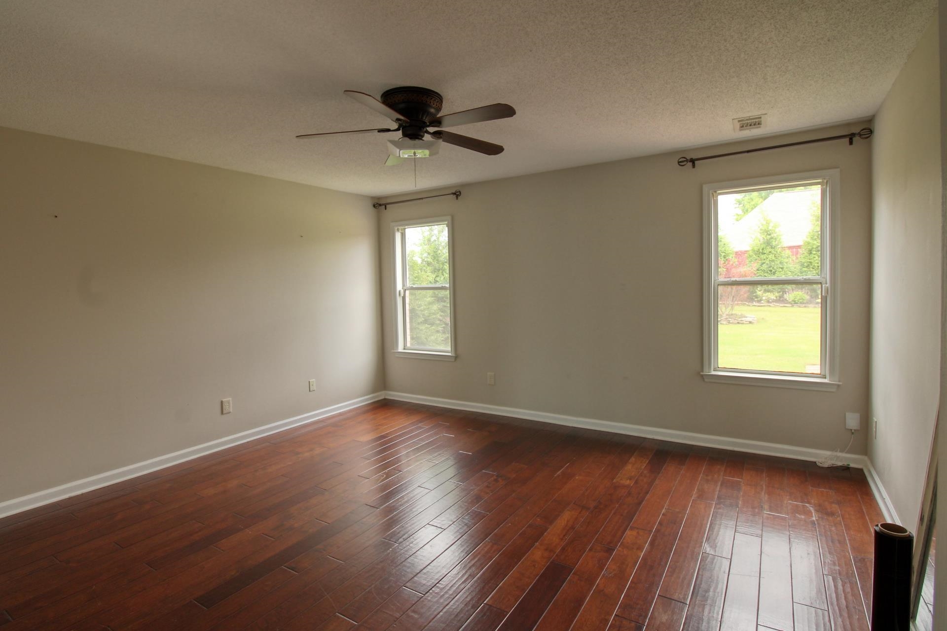25 Whispering Ridge Cove Oakland, TN 38060 - Photo 11 of 19 Spacious room featuring rich wood-finish flooring, neutral wall tones, and two windows providing natural illumination