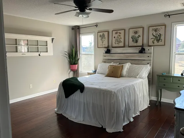 a bedroom with a bed and wooden floor