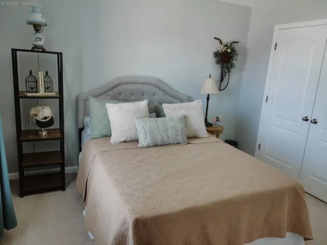 a bedroom with a bed and painting on the wall