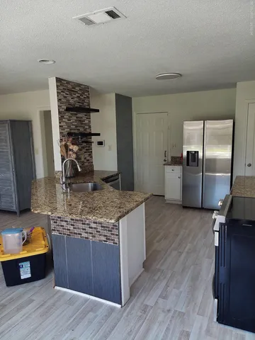 a kitchen with stainless steel appliances granite countertop a lot of counter space and wooden floor