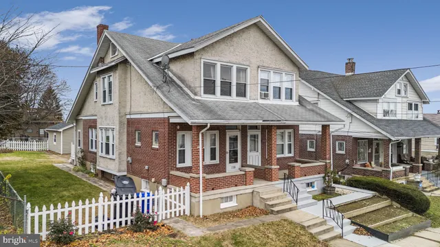 a view of a house with wooden deck and furniture