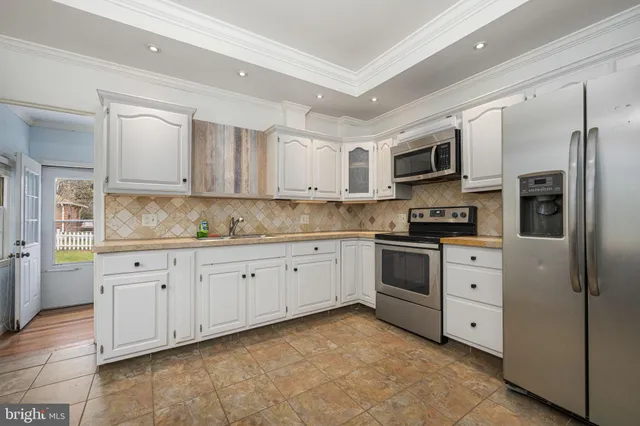 a kitchen with stainless steel appliances granite countertop a refrigerator sink and stove