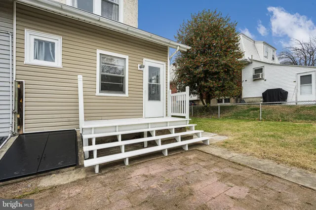 a view of a house with backyard and a tree
