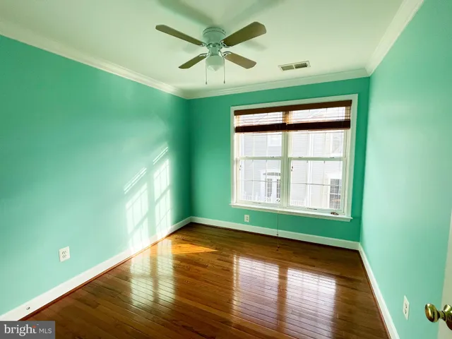 a view of empty room with window and wooden floor