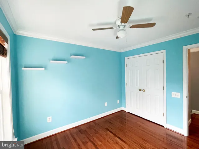 a view of room with hardwood floor and ceiling fan