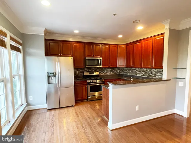 a kitchen with stainless steel appliances granite countertop a refrigerator and a stove top oven