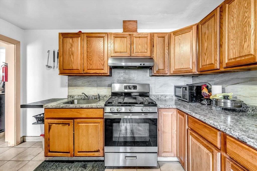 112 Serrano Place Soledad, CA 93960 - Photo 10 of 19 a kitchen with granite countertop a stove sink and cabinets
